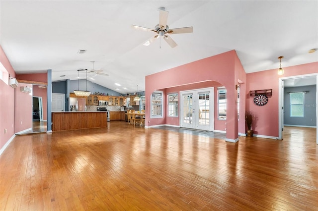 unfurnished living room with ceiling fan, french doors, lofted ceiling, and hardwood / wood-style flooring