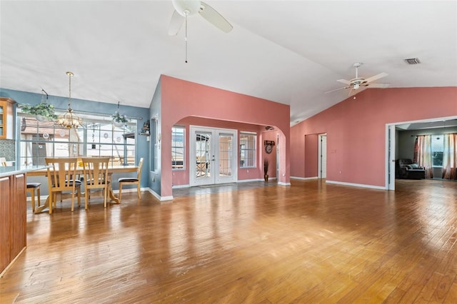 living room with hardwood / wood-style floors, ceiling fan with notable chandelier, and vaulted ceiling