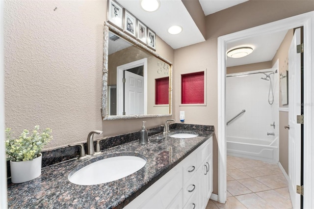 bathroom featuring tile patterned flooring, vanity, and tiled shower / bath combo