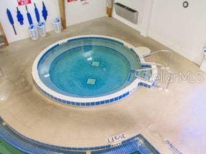 view of swimming pool with a hot tub