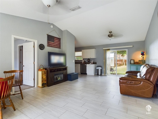 living room featuring ceiling fan, sink, and vaulted ceiling