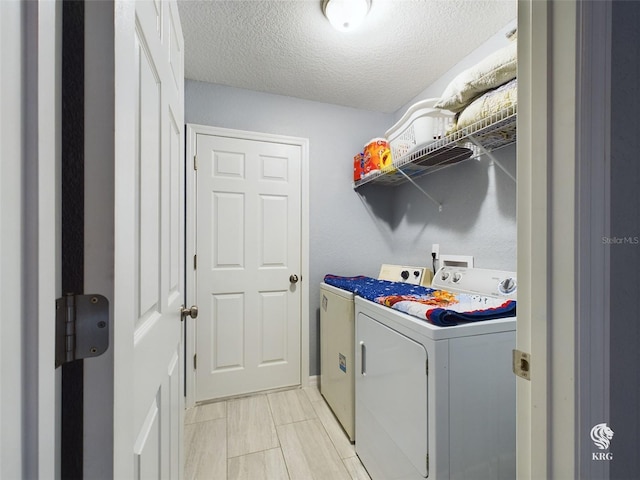 washroom with washing machine and clothes dryer and a textured ceiling