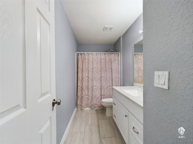 bathroom with walk in shower, vanity, a textured ceiling, and toilet