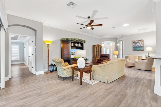 living room featuring ceiling fan, light wood-type flooring, and ornamental molding