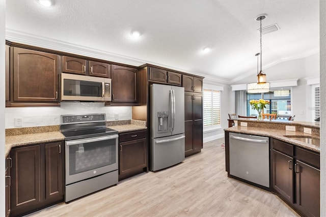 kitchen with dark brown cabinetry, light hardwood / wood-style flooring, decorative light fixtures, vaulted ceiling, and appliances with stainless steel finishes