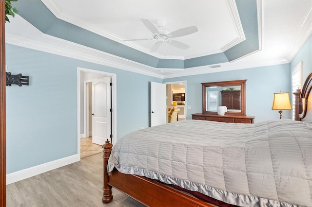 bedroom with light wood-type flooring, a raised ceiling, ceiling fan, and crown molding