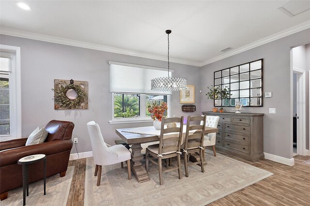 dining area with light hardwood / wood-style flooring, plenty of natural light, and crown molding