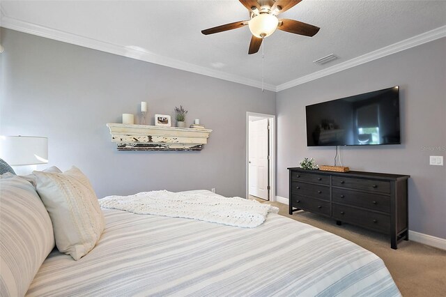 carpeted bedroom with a textured ceiling, ceiling fan, and crown molding