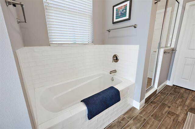 bathroom featuring hardwood / wood-style flooring and independent shower and bath