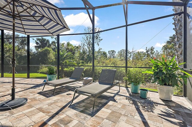 view of patio featuring glass enclosure