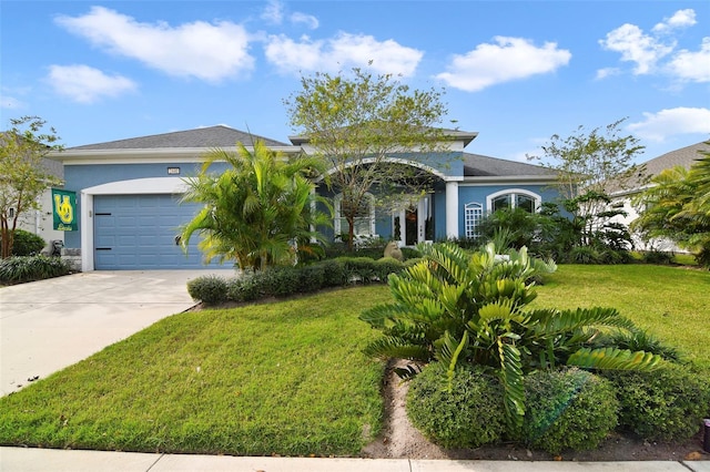 view of front of property featuring an attached garage, concrete driveway, a front yard, and stucco siding