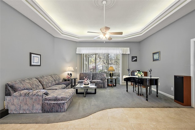 living room featuring carpet, ceiling fan, ornamental molding, and a tray ceiling