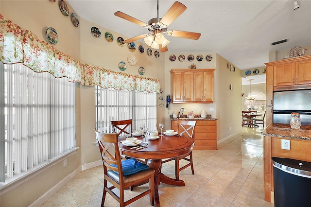 dining room with a textured ceiling, ceiling fan, and light tile patterned flooring