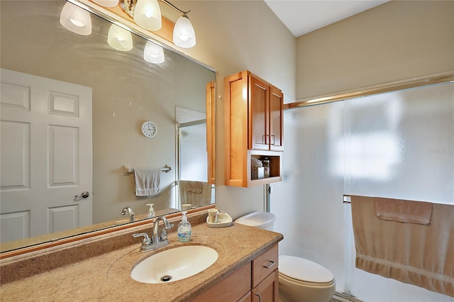 bathroom featuring vanity, toilet, and a shower with shower door