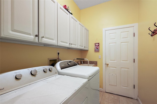 laundry room with separate washer and dryer, light tile patterned floors, and cabinets