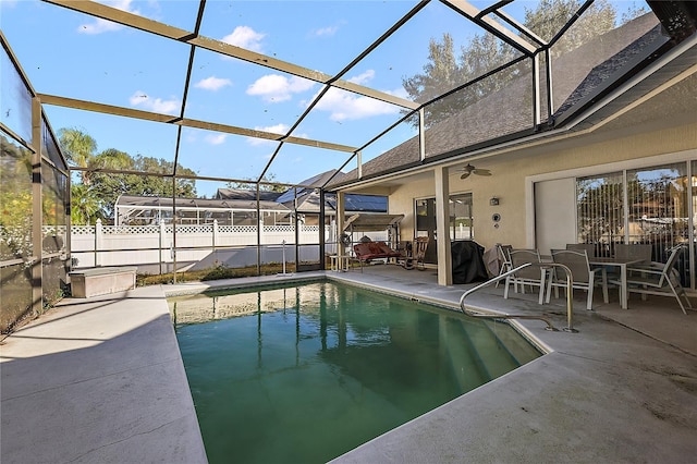 view of swimming pool featuring glass enclosure, ceiling fan, and a patio area