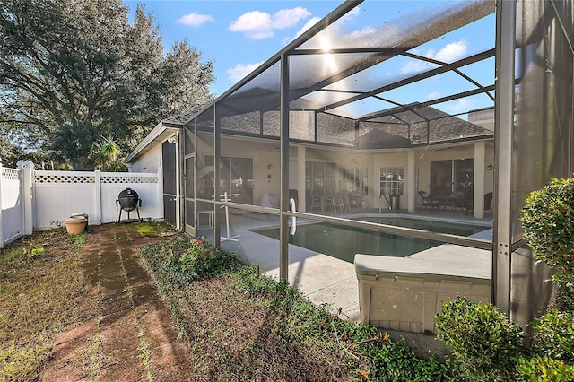 view of pool with glass enclosure and a patio area