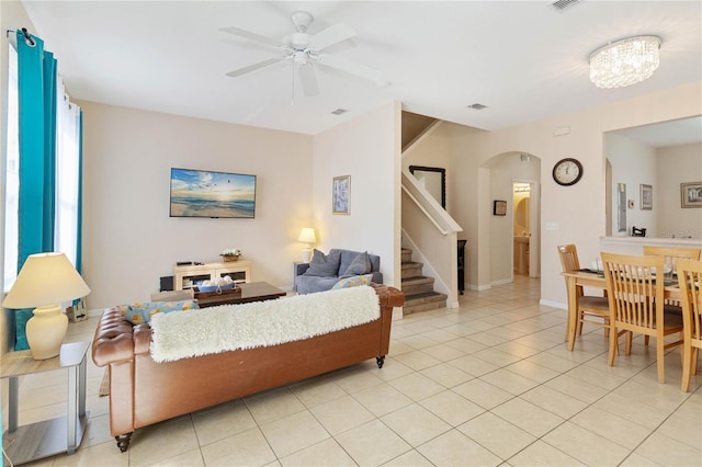 living room featuring light tile patterned flooring and ceiling fan with notable chandelier