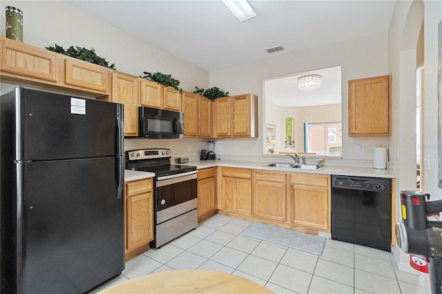 kitchen with sink, light brown cabinets, an inviting chandelier, light tile patterned flooring, and black appliances