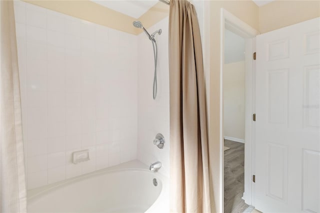 bathroom featuring wood-type flooring and shower / bath combination with curtain