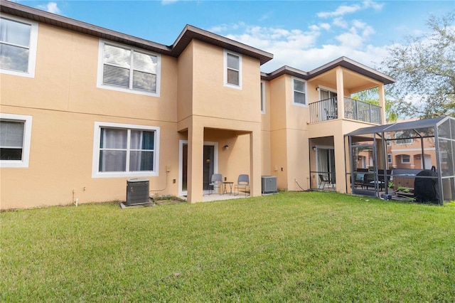 rear view of house featuring a yard, a patio, a balcony, and a lanai