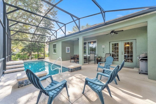 view of swimming pool with glass enclosure, ceiling fan, french doors, a grill, and a patio area