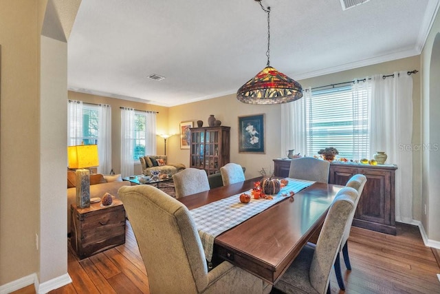 dining space featuring hardwood / wood-style floors and ornamental molding