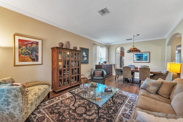 living room featuring crown molding, hardwood / wood-style floors, and a textured ceiling