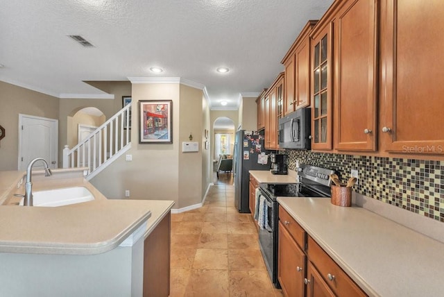 kitchen featuring backsplash, sink, ornamental molding, a textured ceiling, and stainless steel appliances