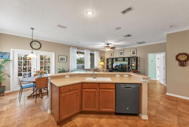 kitchen with a textured ceiling, a kitchen island with sink, sink, pendant lighting, and dishwasher