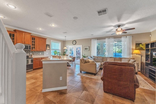 kitchen with appliances with stainless steel finishes, a textured ceiling, crown molding, and pendant lighting