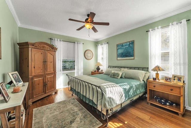 bedroom with hardwood / wood-style flooring, ceiling fan, ornamental molding, and a textured ceiling