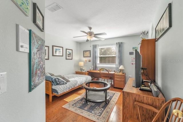 interior space featuring hardwood / wood-style floors, a textured ceiling, and ceiling fan