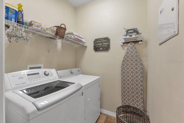 clothes washing area with hardwood / wood-style floors and washing machine and clothes dryer