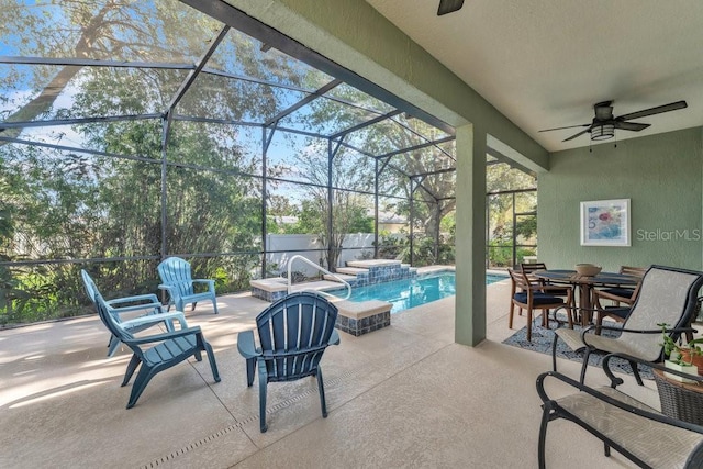 view of patio / terrace featuring ceiling fan, a pool with hot tub, and glass enclosure