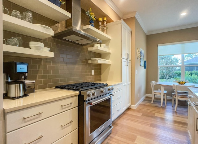 kitchen featuring stainless steel range, white cabinets, exhaust hood, and light wood-type flooring