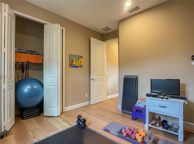 workout room featuring light hardwood / wood-style floors