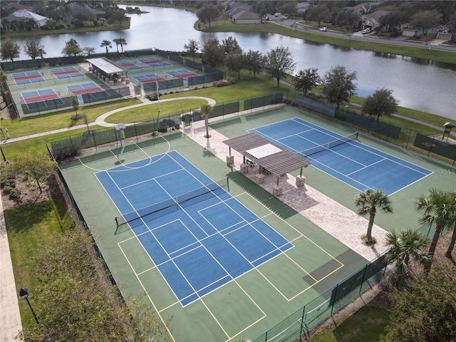 view of sport court with a yard and a water view