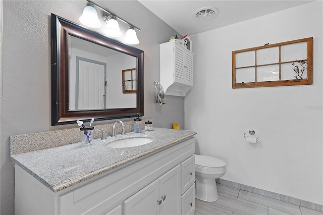 bathroom with hardwood / wood-style floors, vanity, and toilet