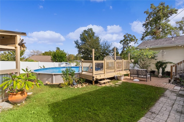 view of pool with a lawn and a wooden deck