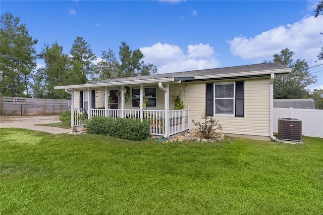 ranch-style house featuring a porch, a front lawn, and central air condition unit