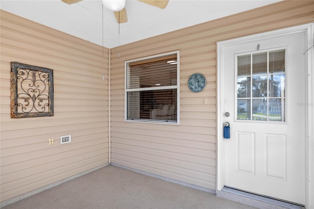 view of exterior entry featuring ceiling fan