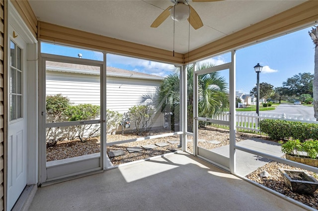 unfurnished sunroom featuring plenty of natural light and ceiling fan