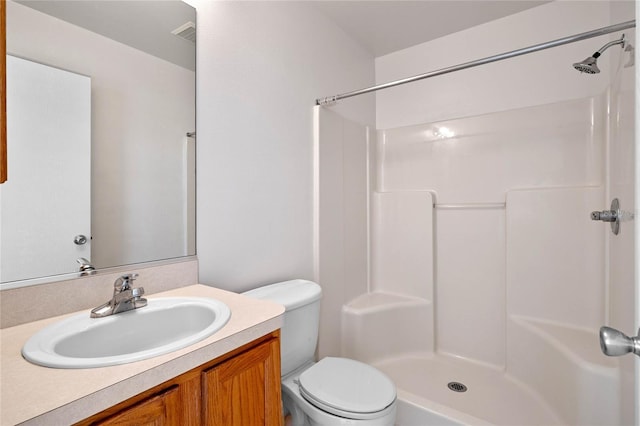 bathroom with vanity, toilet, and a shower