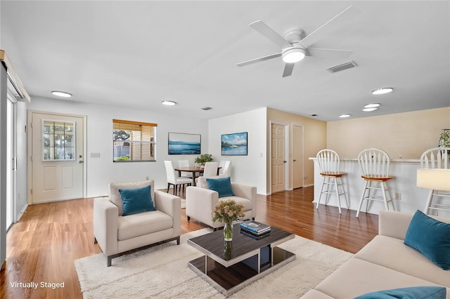 living room with hardwood / wood-style floors and ceiling fan