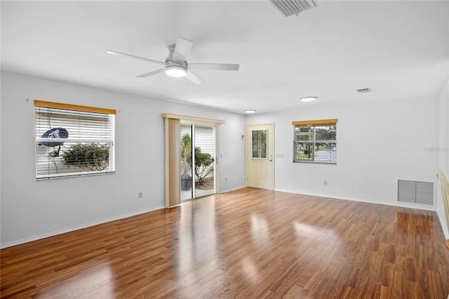 empty room with hardwood / wood-style flooring, plenty of natural light, and ceiling fan