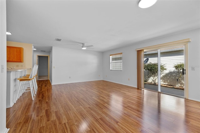 unfurnished living room with light wood-type flooring and ceiling fan