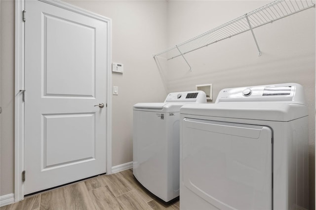 laundry room featuring independent washer and dryer and light wood-type flooring