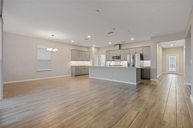 unfurnished living room with a notable chandelier and sink