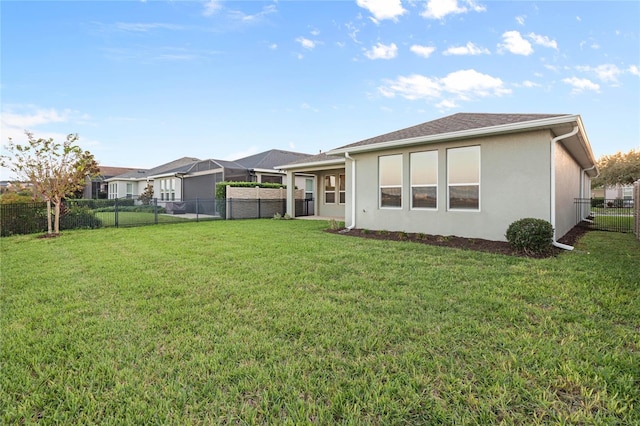 rear view of property featuring a lawn